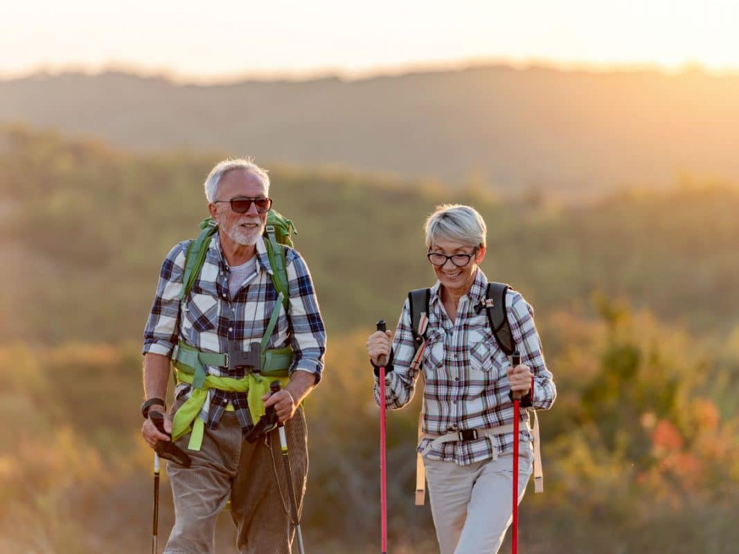 Healthy mature couple walking outdoors representing healthy liver support and wellbeing.